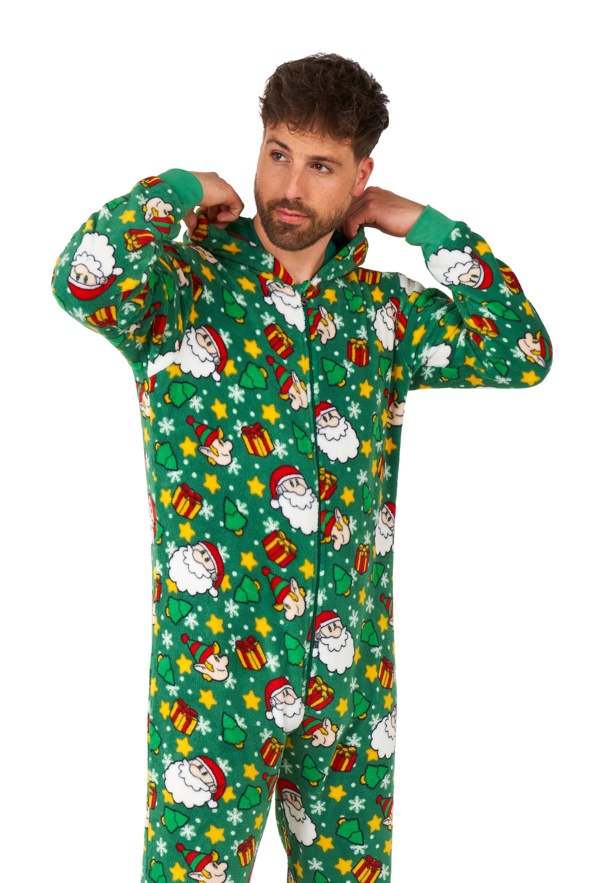 A man adjusts the hood of his green "Santa Elves" Christmas onesie by Suitmeister, featuring Santa Claus, presents, stars, and stockings.