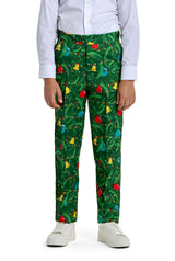A child models the Suitmeister BOYS Christmas Green Tree - Light Up outfit, featuring a white dress shirt and green pants with festive tree and ornament patterns, paired with white sneakers. Photo is cropped from shoulders to feet.