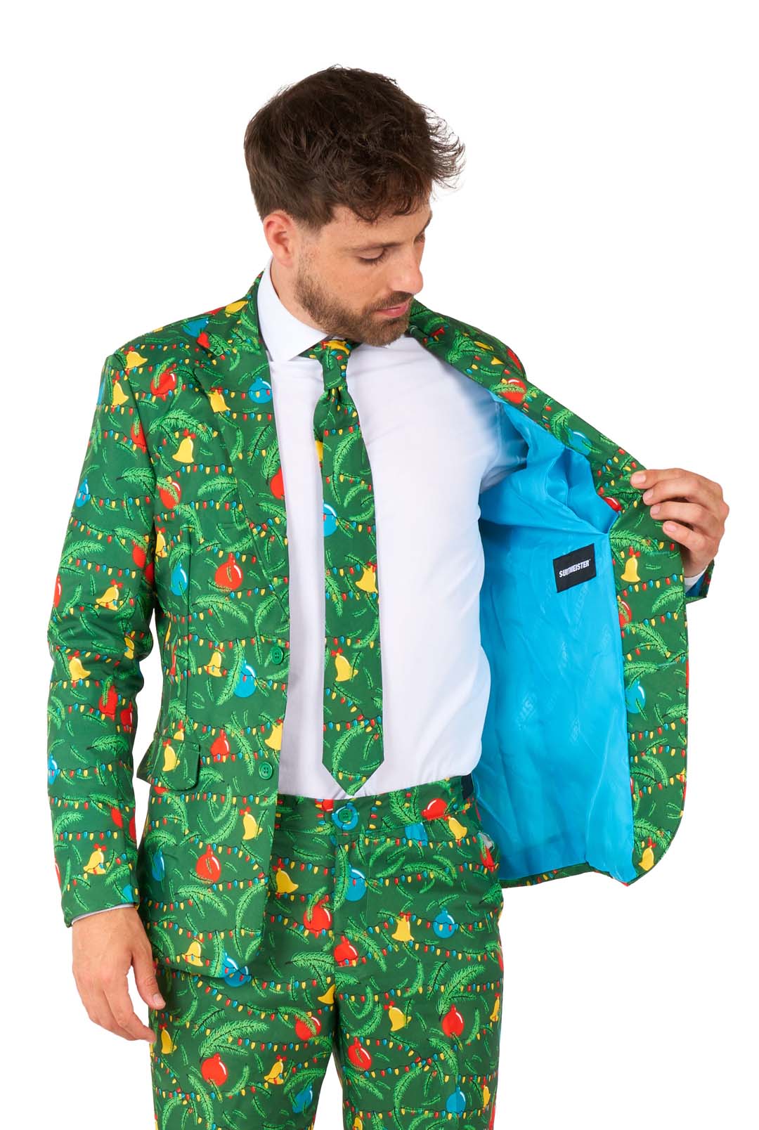 A man wears the Suitmeister Christmas Green Tree - Light Up suit featuring colorful Christmas ornament and light designs. He opens his jacket to reveal a bright blue lining, paired with a matching tie and a white shirt.