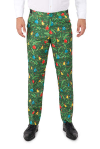 A person wearing Suitmeister's Christmas Green Tree - Light Up pants, featuring a festive holiday lights pattern, paired with a white dress shirt and black dress shoes, stands against a white background.