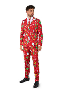 A man wears the Suitmeister Christmas Red Icons - Light Up suit, featuring festive patterns like snowmen, trees, and ornaments, paired with a white shirt and red tie. He looks to the side.