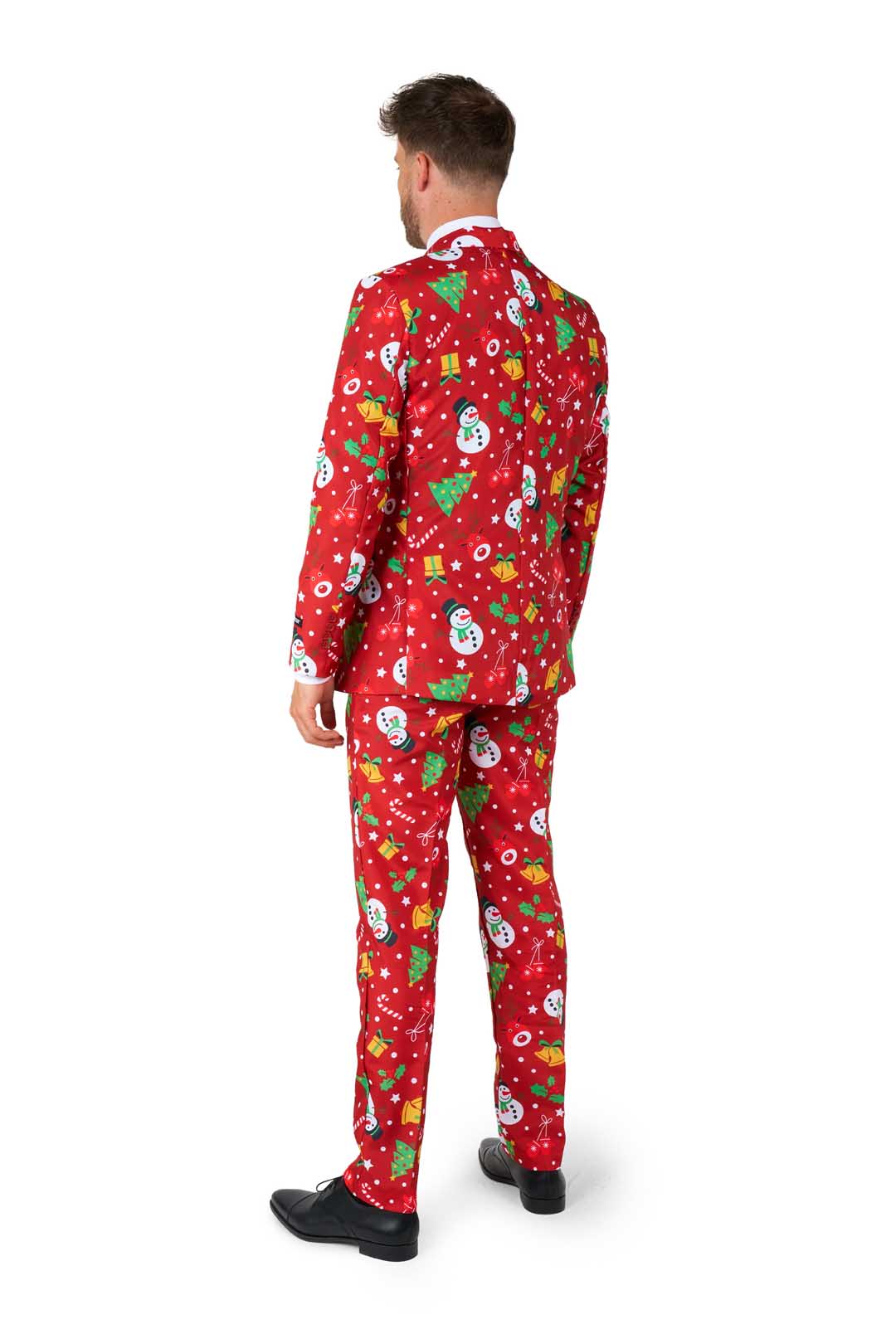 A man faces away, dressed in the Suitmeister Christmas Red Icons - Light Up suit featuring snowmen, Christmas trees, presents, and white snowflakes. He wears black shoes and stands against a plain white background.