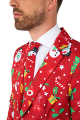 A man wearing the Suitmeister Christmas Red Icons – Light Up suit jacket and tie featuring festive patterns like snowmen, candy canes, holly, ornaments, and presents over a white dress shirt.