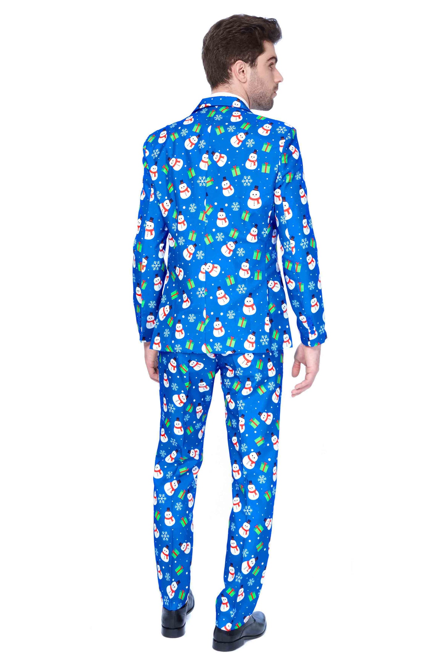 A man faces away, dressed in the Suitmeister Christmas Blue Snowman suit, featuring colorful Christmas-themed patterns like snowmen and gifts. He has short brown hair and is wearing black shoes against a plain white background.