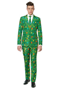 A man is wearing the Suitmeister "Christmas Green Tree" suit, featuring a festive pattern adorned with red, yellow, and blue ornaments. He pairs it with a white shirt and a matching tie. He's standing against a white background, gazing directly at the camera.