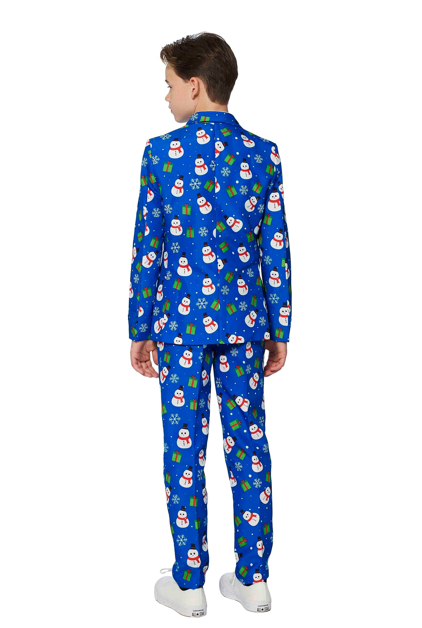 A boy is standing with his back turned, wearing the "Christmas Suit Blue Snowman" by Suitmeister. This vibrant suit features a festive snowman and gift pattern in bright colors such as red, white, and green accents. He has paired it with crisp white sneakers.