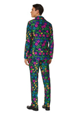 A person dressed in a vibrant Suitmeister Floral suit, characterized by a navy background adorned with bright pink, yellow, and green flowers. The individual is standing with their back to the camera and wearing black shoes.