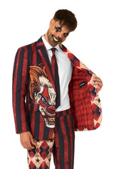Man smiling eerily while opening red scary clown suit jacket to reveal inner red diamond lining, part of a bold men’s Halloween costume.