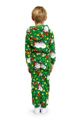 The child is dressed in a Suitmeister's Santa Elves Green - Christmas Onesie, which features Santa Claus, gifts, and stars, and includes a hood. The child stands facing away while wearing white socks.